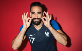 French football player Adil Rami on a red background