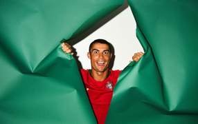 Funny face of football player Cristiano Ronaldo on a green background