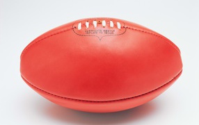 Red American football ball on white background
