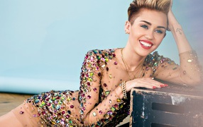 Smiling singer Miley Cyrus in a shiny dress