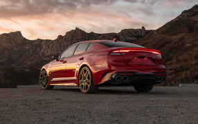 Red car Kia Stinger GT, 2022 in the mountains, rear view
