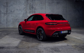 Красный автомобиль Porsche Macan GTS 2021 года на сером фоне вид сзади