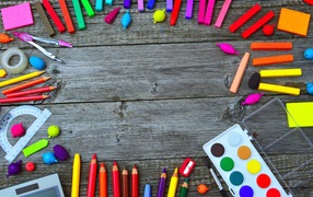 Rainbow of bright stationery for school on wooden table
