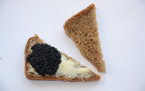 Black bread sandwiches with black caviar on a gray background