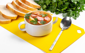 Вкусный суп солянка на столе с хлебом и петрушкой