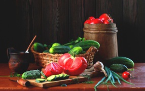 Свежие огурцы и помидора на столе с зеленым луком