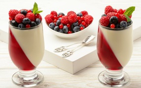 Двухцветный десерт с ягодами на столе 