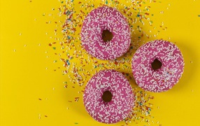 Пончики с розовой глазурью на желтом фоне