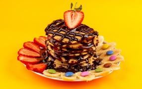 Fritters with chocolate, strawberry and banana on a yellow background