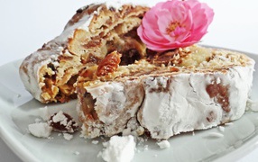 Кусок пирога на белой тарелке с цветком розы 