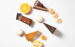 Pieces of cake on a white plate with tangerine and lemon
