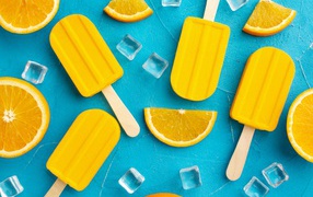 Фруктовое мороженое с кусочками льда и апельсина на голубом столе 