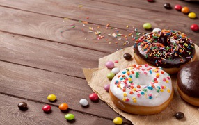 Сладкие пончики с глазурью на столе с конфетами