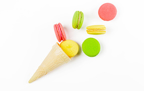 Waffle cone with macaroon cookies on white background