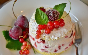 Пирожное со взбитыми сливками украшено ягодами