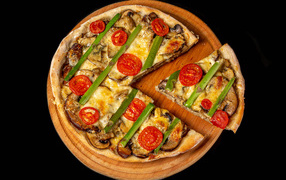 Вкусная вегетарианская пицца с помидорами и шампиньонами на черном фоне