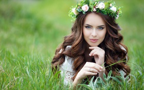Девушка с красивыми длинными волосами лежит на траве