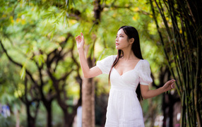 Asian girl in white dress by the tree