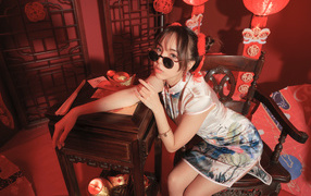 Девушка азиатка в очках сидит в кафе