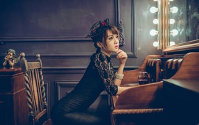 Красивая девушка азиатка в черном платье сидит в кафе
