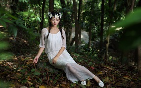 Красивая девушка азиатка в белом платье  в лесу