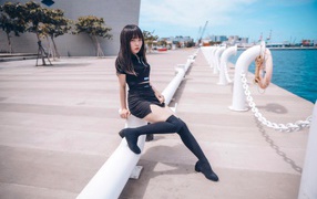 Beautiful asian girl in black boots on the pier