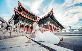 Красивая азиатка в белом платье на фоне храма