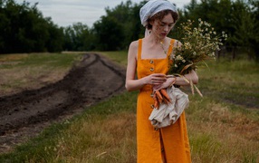 Красивая девушка с букетом полевых ромашек 