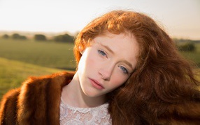 Beautiful red-haired girl in a fur coat
