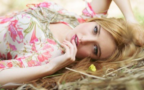 Красивая молодая блондинка лежит на траве