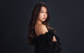 Cute asian girl in a black outfit on a gray background