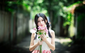 Милая девушка азиатка с букетом розовых роз 