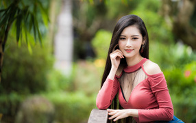 Милая улыбающаяся девушка азиатка розовой кофте