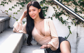 Улыбающаяся девушка азиатка с черными волосами на ступенях 