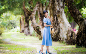 Stylish asian girl in a blue dress in the park