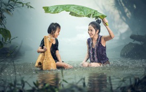 Two Asian girls in the rain in the water