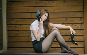 Молодая азиатка с черными туфлями в руках 