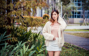 Young asian girl in a white sweater in the park