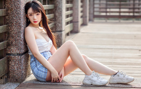 Молодая девушка азиатка в белых кроссовках 