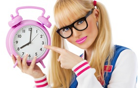 Young blonde with a pink clock in her hands