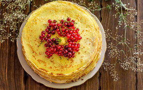 Appetizing pancakes with red currant berries on the table