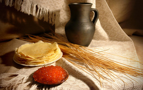 Pancakes with caviar on a table with ears of wheat for Maslenitsa