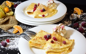 Thin pancakes with berries and powdered sugar for Shrovetide