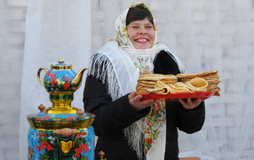 Woman with pancakes and samovar at Shrovetide