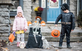 Маленькие дети со скелетом на праздник Хэллоуин