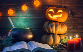 Pumpkin, magic book and candles on the table for Halloween