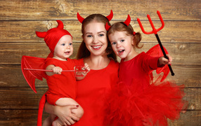 Woman with two children in red halloween costumes