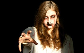 Zombie girl on black background in halloween costume