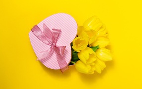 Gift and a bouquet of tulips on a yellow background for International Women's Day