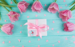 Розовые тюльпаны с подарком на голубом фоне на 8 марта